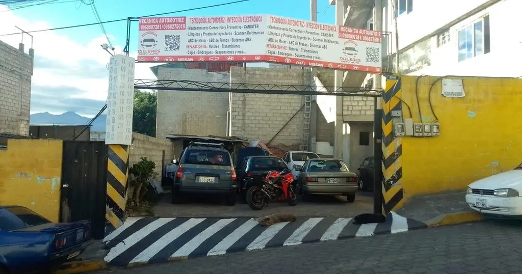 Entrada actual de Talleres Servi Auto con los banners blancos, Av. La Cocha, Tréboles del Sur, sur de Quito
